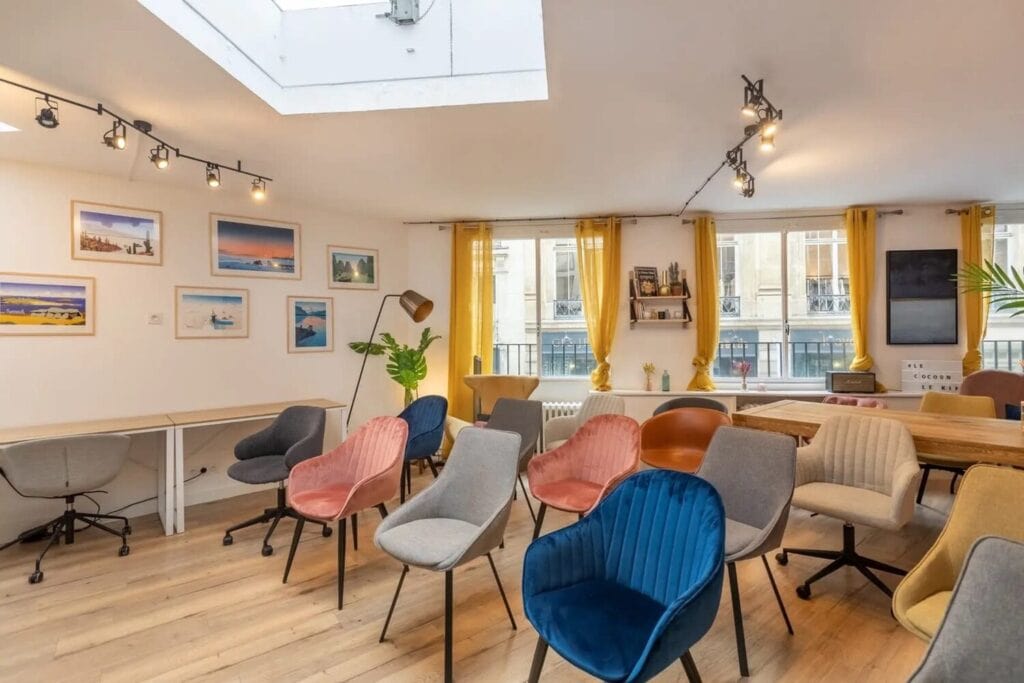 Atelier collaboratif dans une salle lumineuse, avec des fauteuils colorés disposés en cercle.