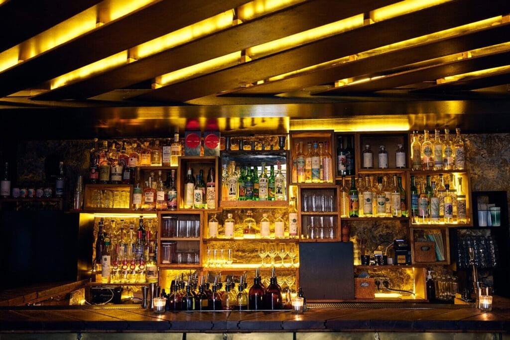 Balise alt	Bar de la Candelaria à Paris, avec rangées de bouteilles rétroéclairées et petites bougies