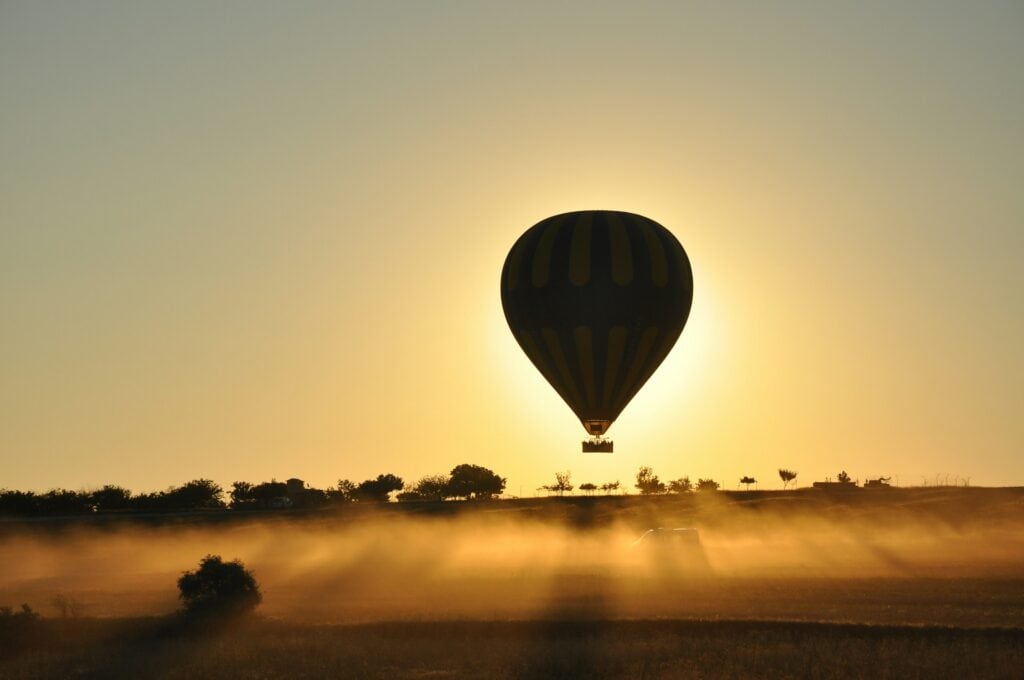 une montgolfière s'élève dans le ciel au lever du soleil