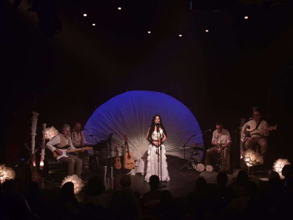 un groupe en concert dans une salle sombre Peerspace