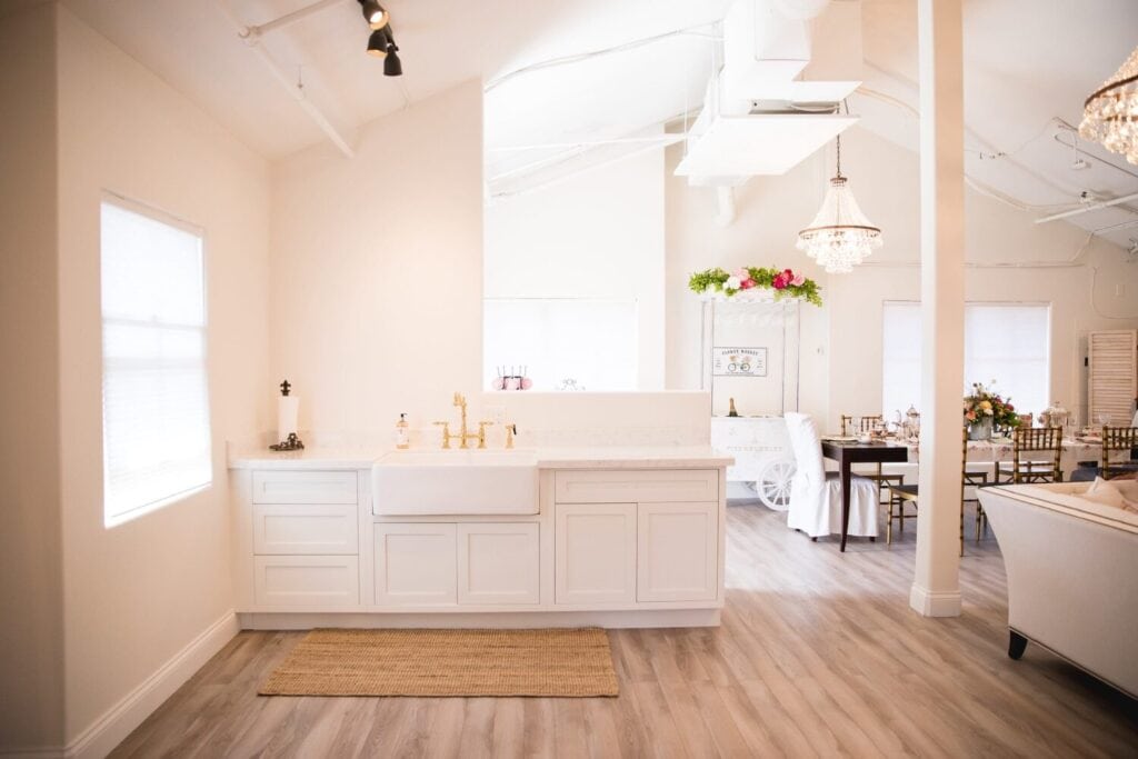 Cuisine ouverte lumineuse avec îlot central, rangements et espace de préparation pour un buffet.