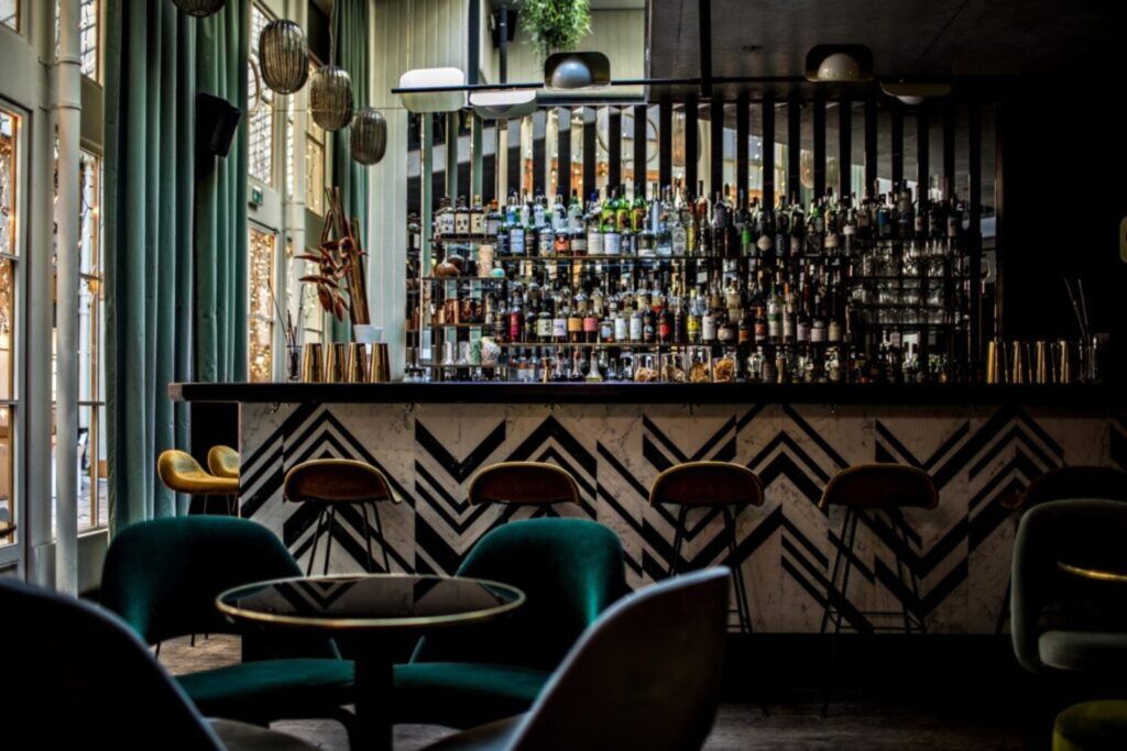 Comptoir en marbre du Danico à Paris, avec fauteuils en velours vert et grande baie vitrée
