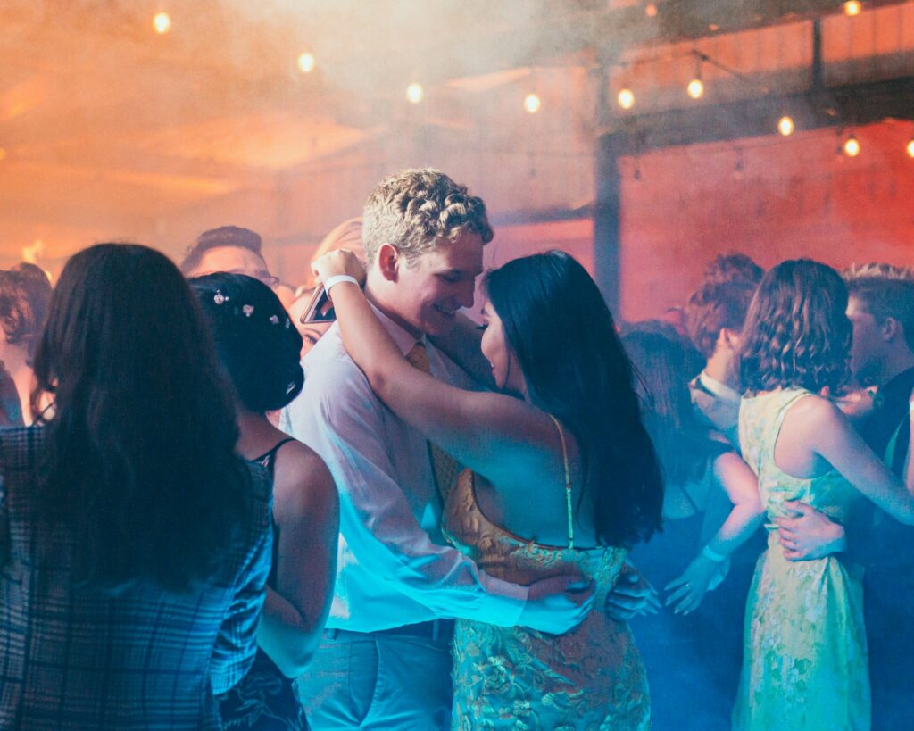 un garçon et une fille dansent sur la piste lors d'un bal de promo américain