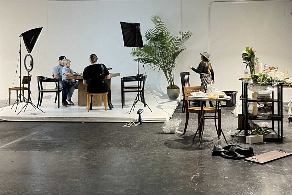 Équipe de production photographiant deux personnes assises autour d'une table.
