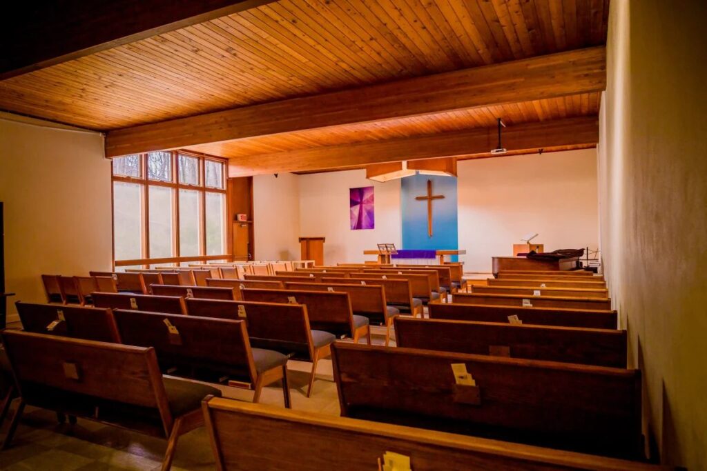 Intérieur sobre d'une église contemporaine à louer avec bancs en bois et plafond en lambris cathédrale.