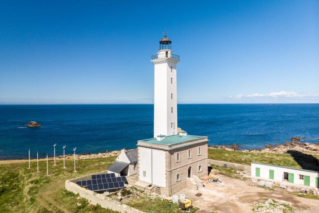 Maison des gardiens et ancien phare de l’Île Vierge face à la mer, vus depuis les airs