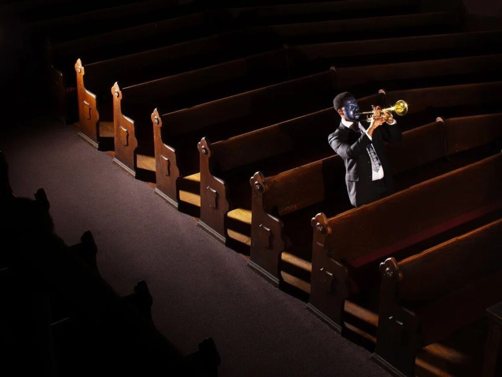 Trompettiste en solo dans une église aux bancs en bois