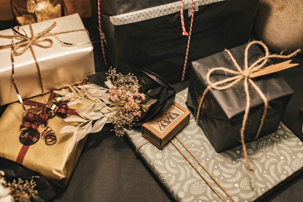 plusieurs paquets cadeaux dorés et noirs entreposés sur le sol