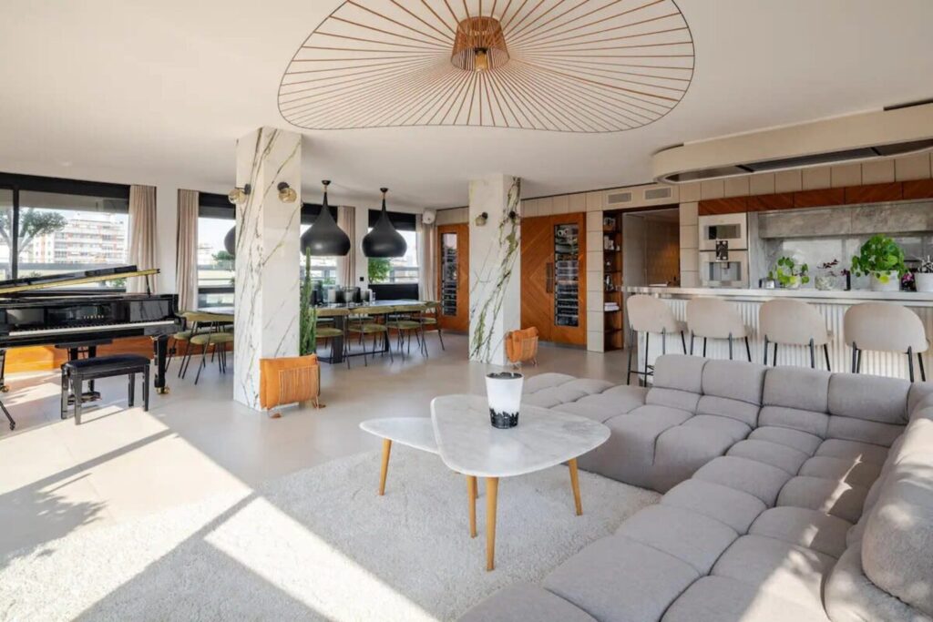Penthouse lumineux avec cuisine ouverte, bar, piano et vaste espace de réception.