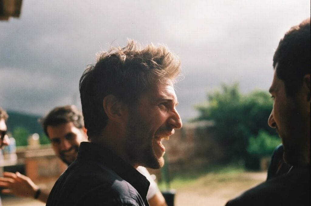 un homme d'une quarantaine d'années rit avec ses amis