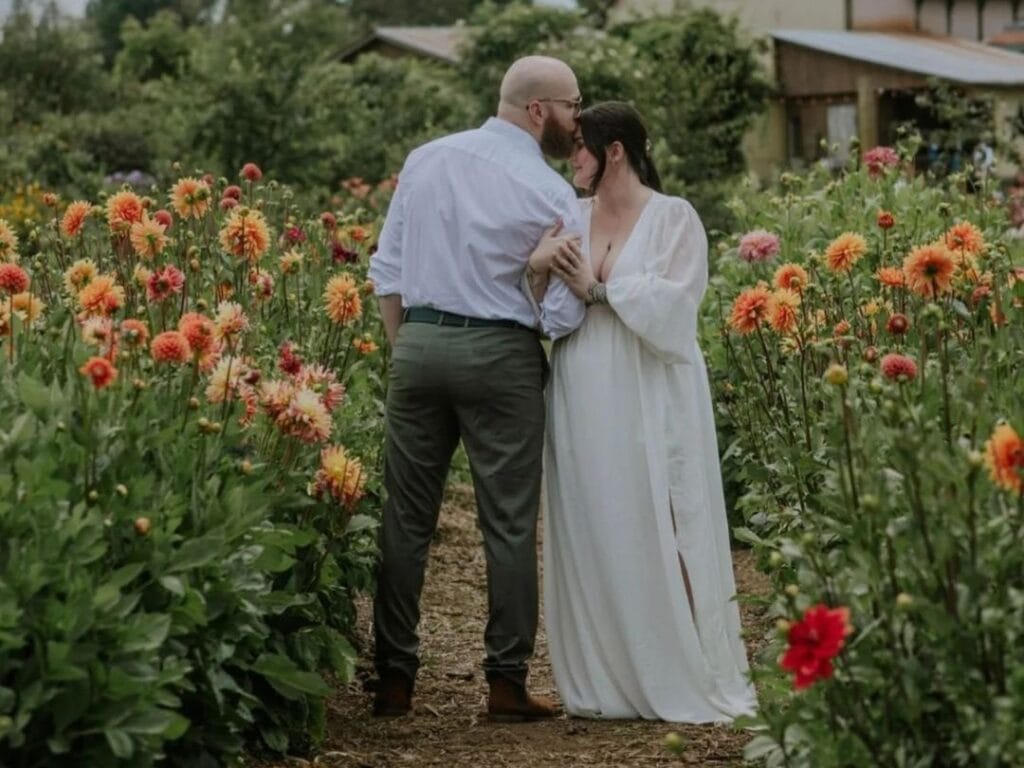 un couple est pris en photo dans un jardin fleuri