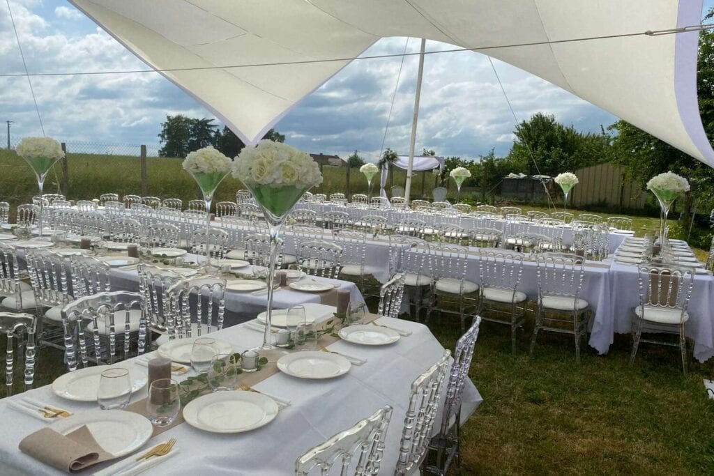 : Tables de réception dressées sous une toile blanche dans un jardin de Seine-et-Marne.
