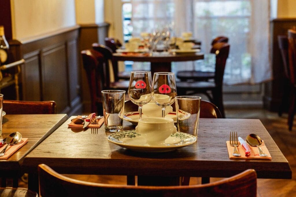 Table dressée dans un restaurant parisien privatisable, avec vaisselle, verres et lumière naturelle.