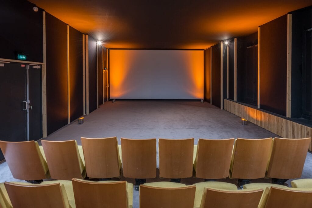 salle de projection avec fauteuils jaunes cosy et grande toile