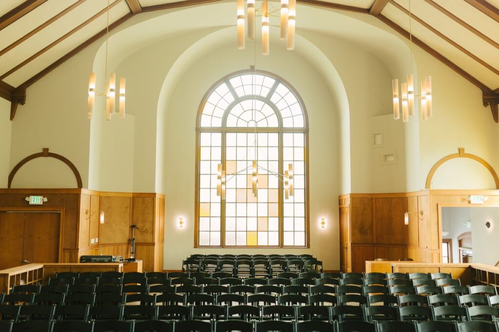 Église désacralisée à louer, aménagée en salle de conférence avec chaises alignées face à une grande baie vitrée.