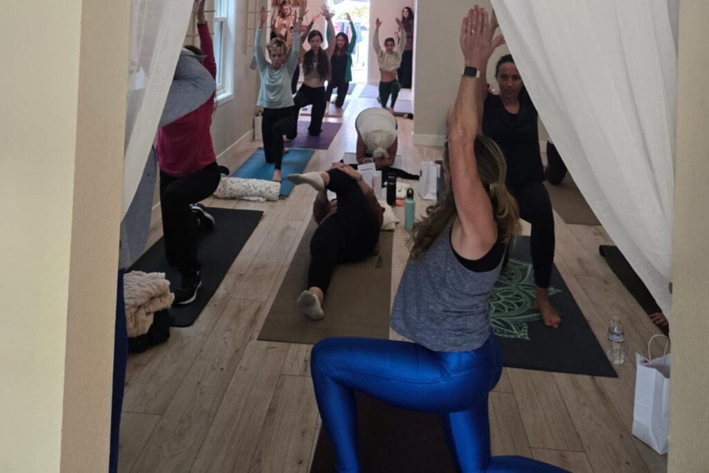 Groupe d’adultes suivant une séance de yoga et de méditation dans un espace bien-être.