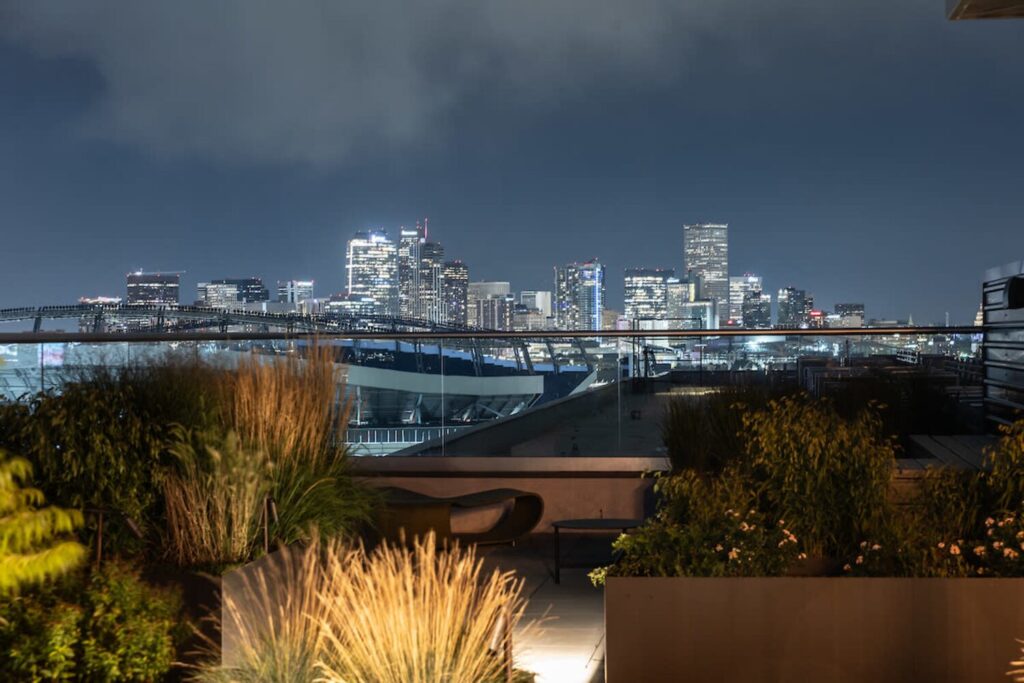 Toit-terrasse de nuit avec vue sur les lumières de la ville pour observer les étoiles.