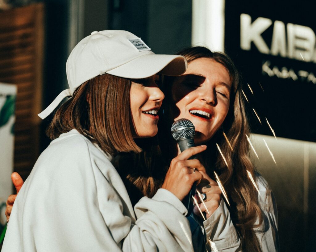 deux jeunes filles chantent dans un micro lors d'un karaoké