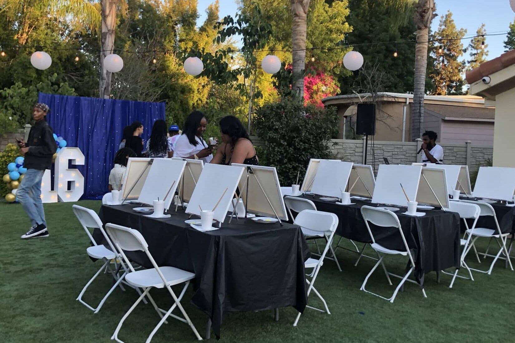 16th birthday teen party in backyard with blank canvases and paint materials on tables