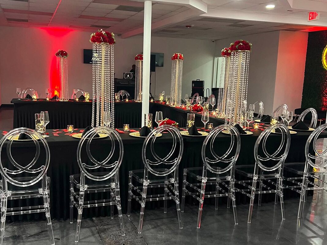 Interior wedding in Atlanta with black tables, clear chairs and red jellyfish-like centerpieces