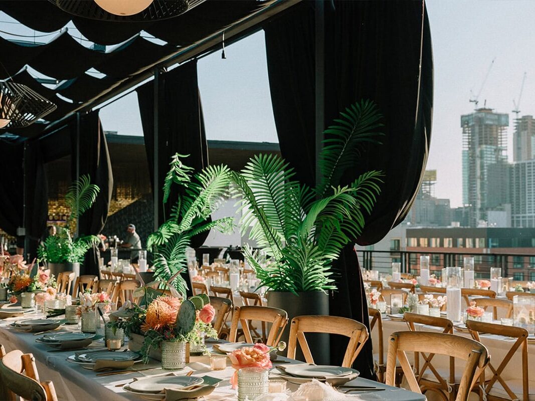 Indoor NY wedding venue with city skyline, green plants and tables and chairs