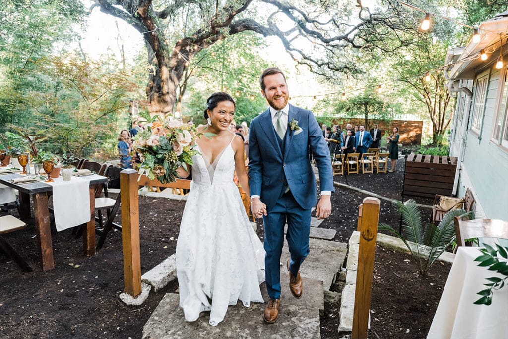 Couple walking holding hands at outdoor wedding venue in Dallas