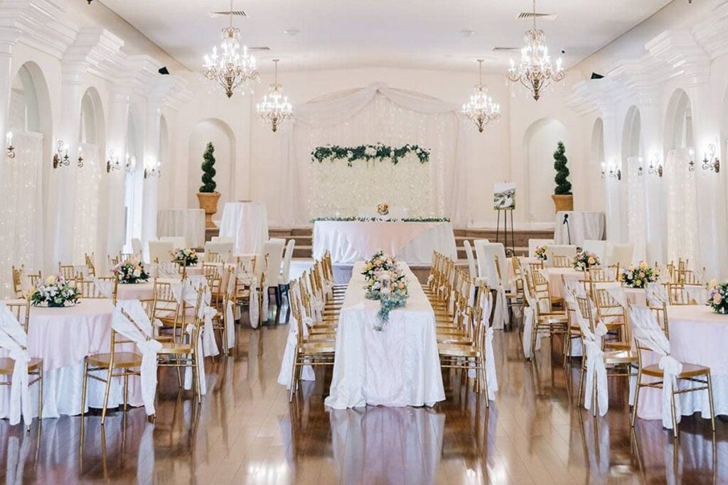 Indoor wedding reception in Tampa with white table cloths, long tables, florals