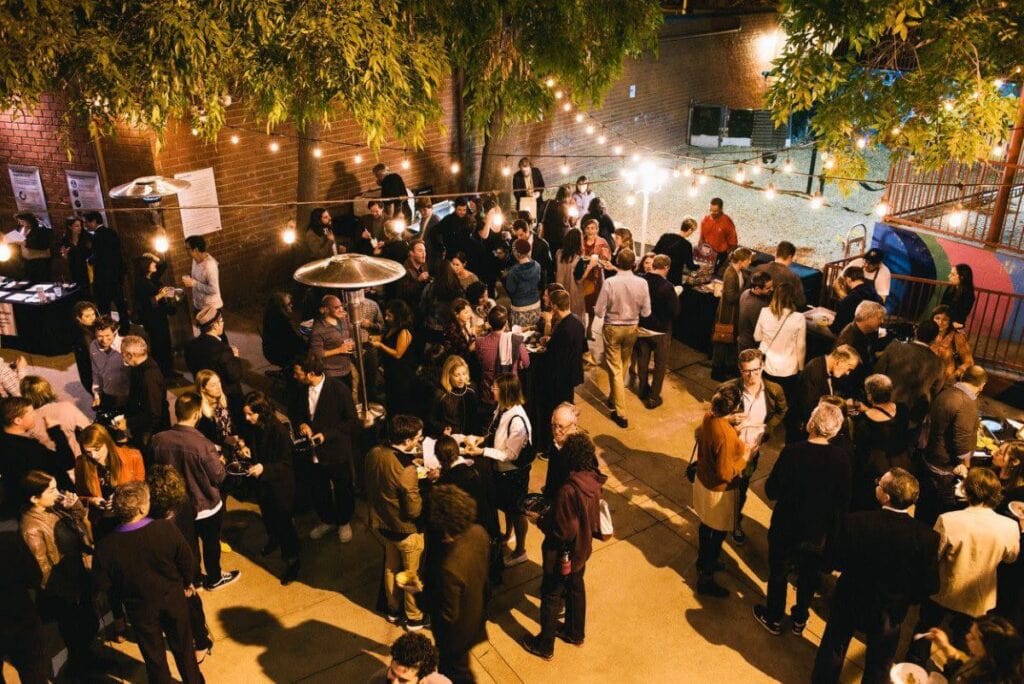 a crowd of party guests in an outdoor courtyard
