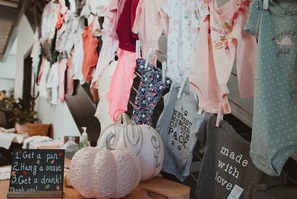 baby shower signage and onesie decor