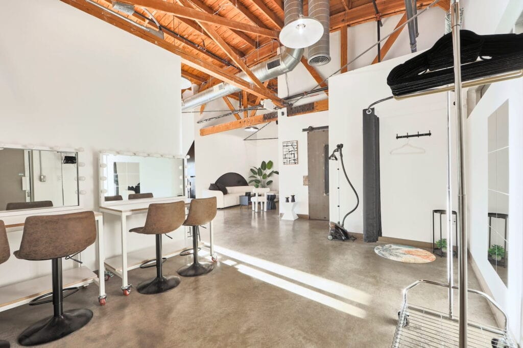 Dressing area at a large, bright studio with wooden beams, makeup mirrors, a changing area and seating