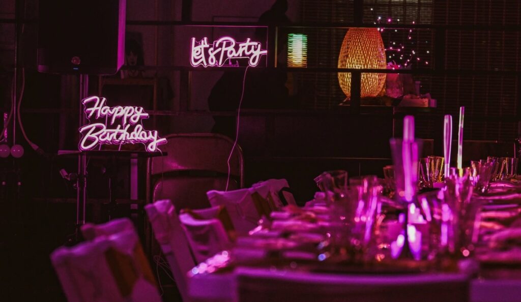 Neon let's party sign set up at a birthday party for decor