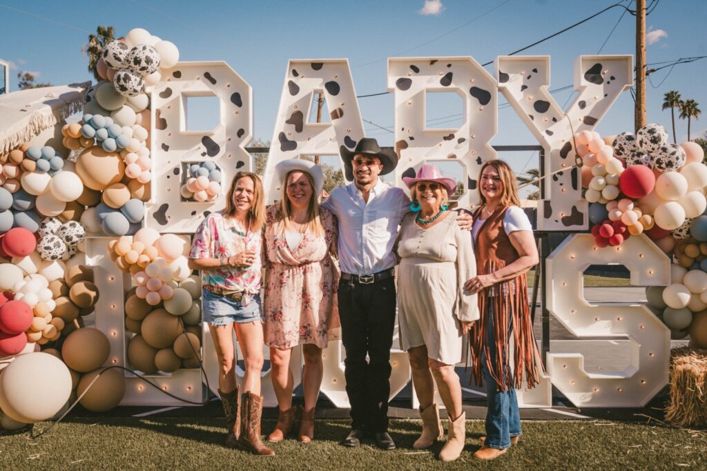 guests taking photo in front of baby shower sign