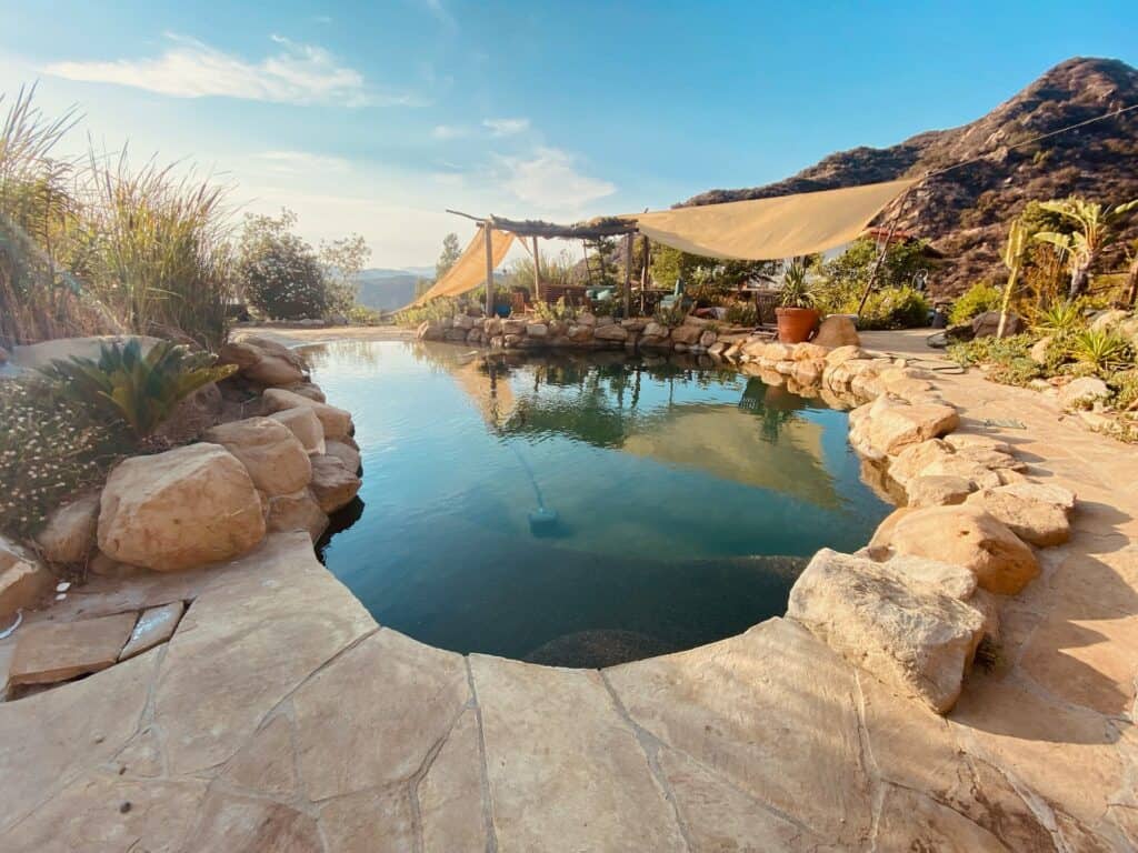 a pool surrounded by hardscaping overlooking a valley