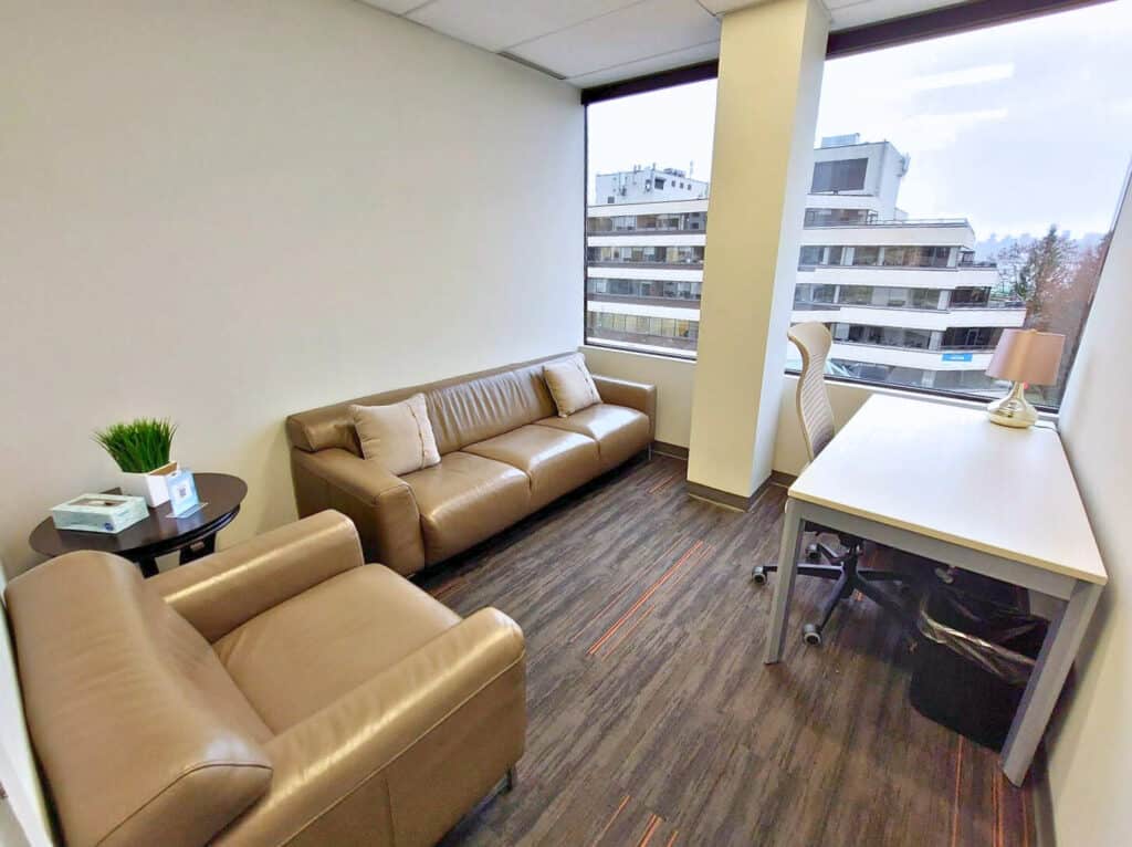 Private therapy office space in Vancouver, Canada, with brown leather couches and a big window