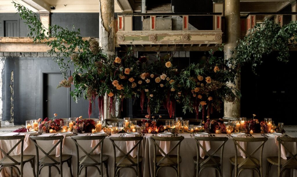 Reception venue in grand building with table, chairs, and florals