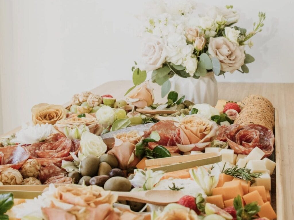 Spread of food including meats, fruit, cheeses, and florals at a PowerPoint party