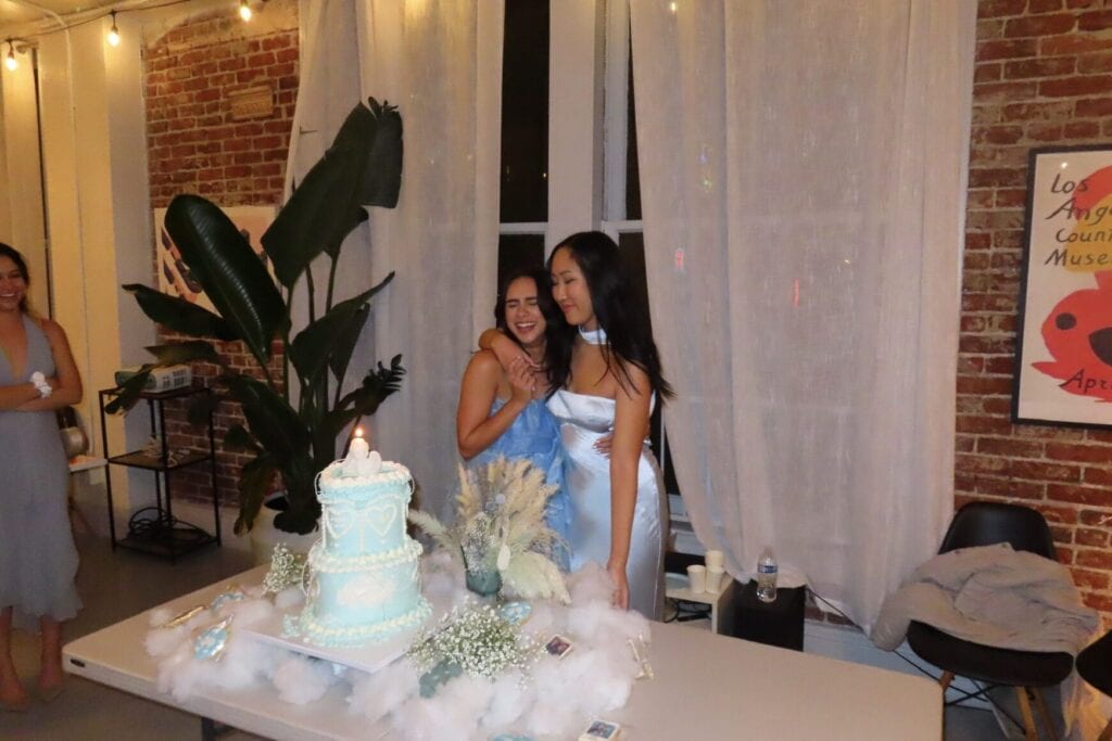 Two friends embracing in front of 22nd birthday cake