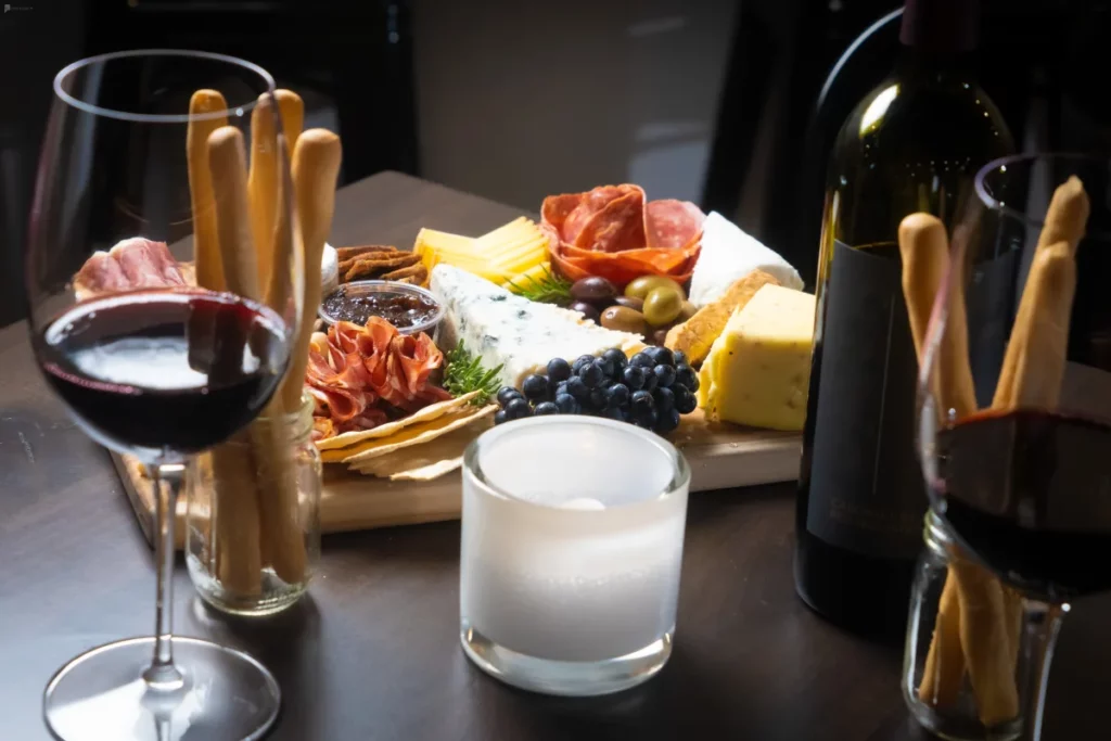a charcuterie board surrounded by wine glasses