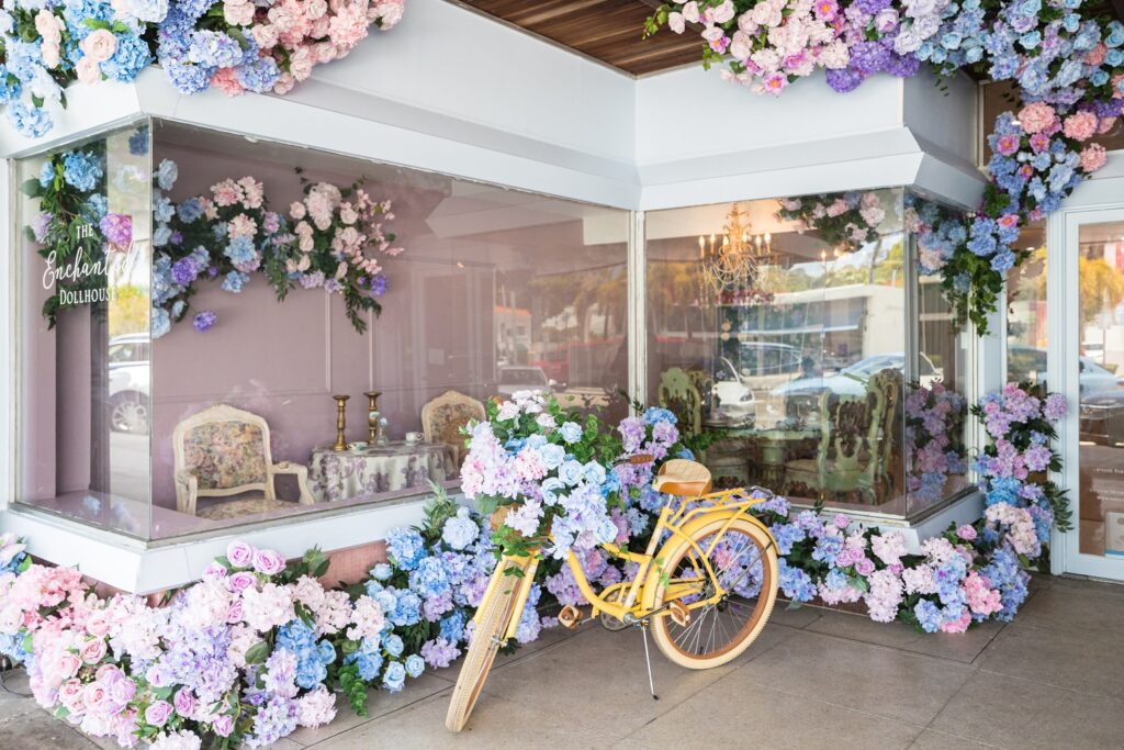 a flower strewn bike in front of a shop