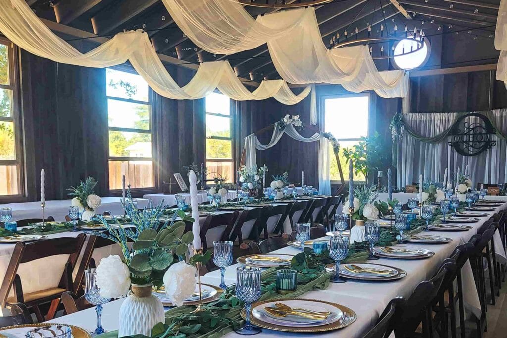 Elegant indoor Arizona wedding reception with draped ceilings and lush greenery