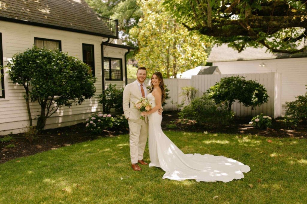 Couple in wedding attire posing in Charlotte wedding venue backyard