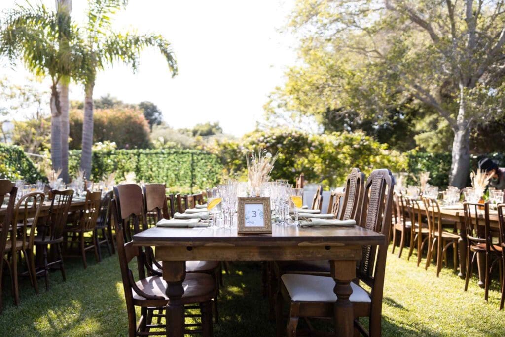 Outdoor wedding wooden table in Hawaii with centerpieces, table numbers