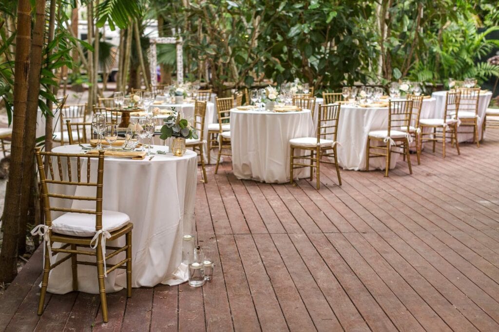 Tables and chairs on wooden floor at outdoor Hawaii wedding