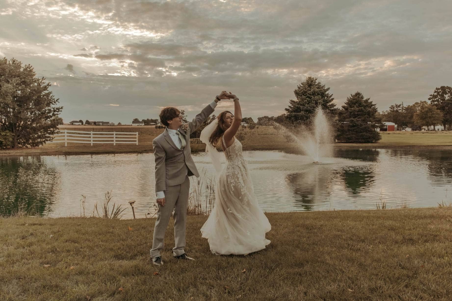 Couple celebrating at a scenic outdoor Maine wedding venue with pond