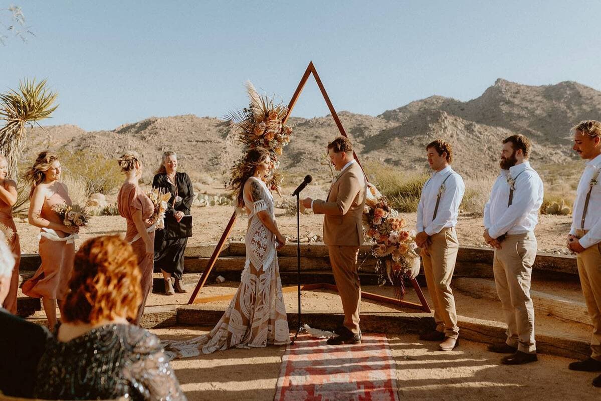 Wedding party at outdoor ceremony with dramatic New Mexico mountain backdrop