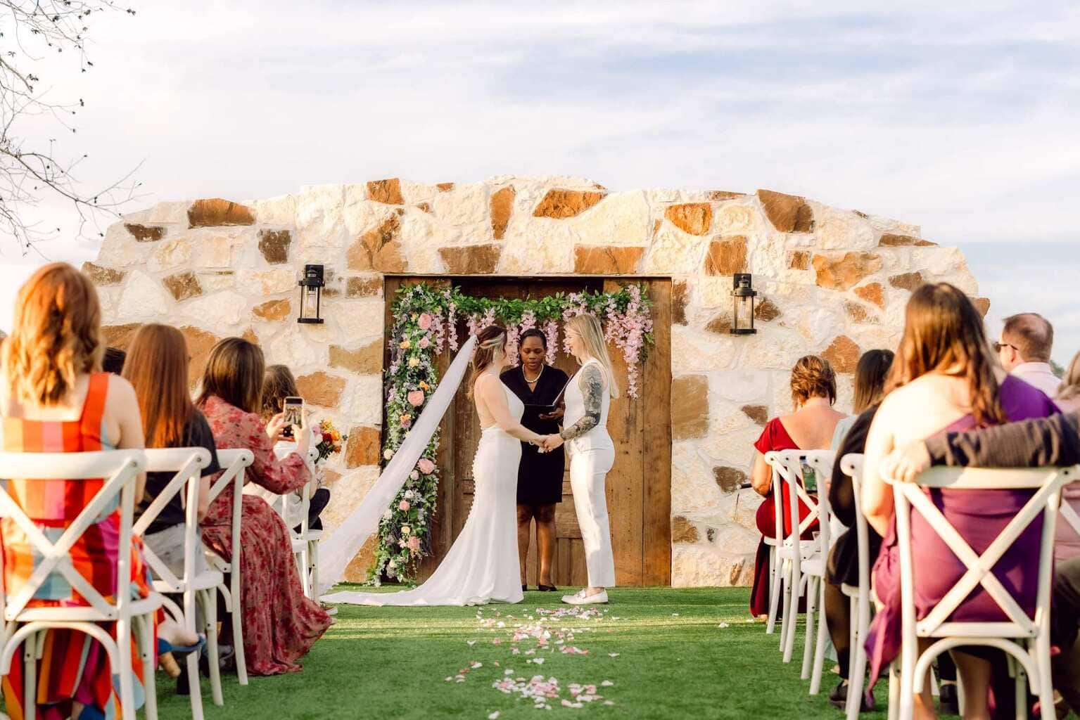 Outdoor New Mexico wedding ceremony with floral arch and seated guests