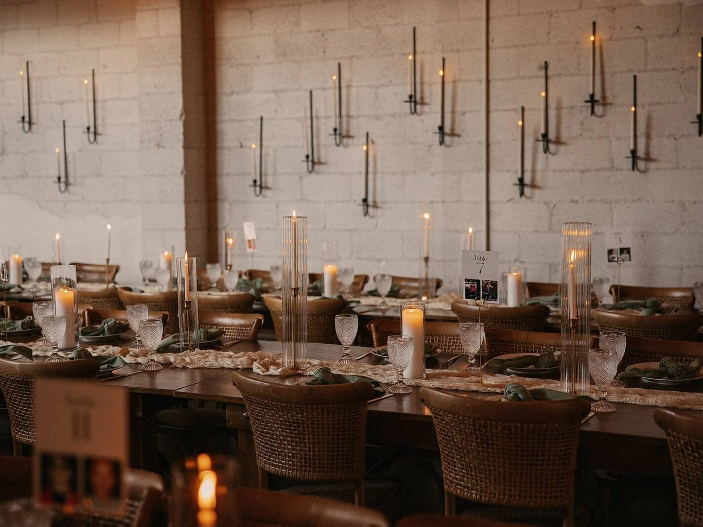 Interior evening photo of New Orleans planned wedding with candles, tables, and place settings