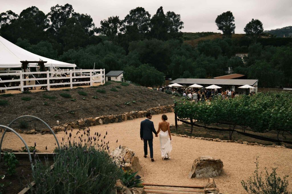 Couple walking through outdoor ranch-style wedding venue in San Antionio 