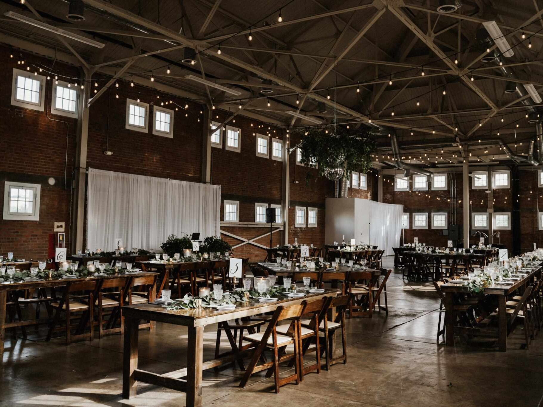 Seattle wedding interior in lofty barn space with fairy lights and wooden tables