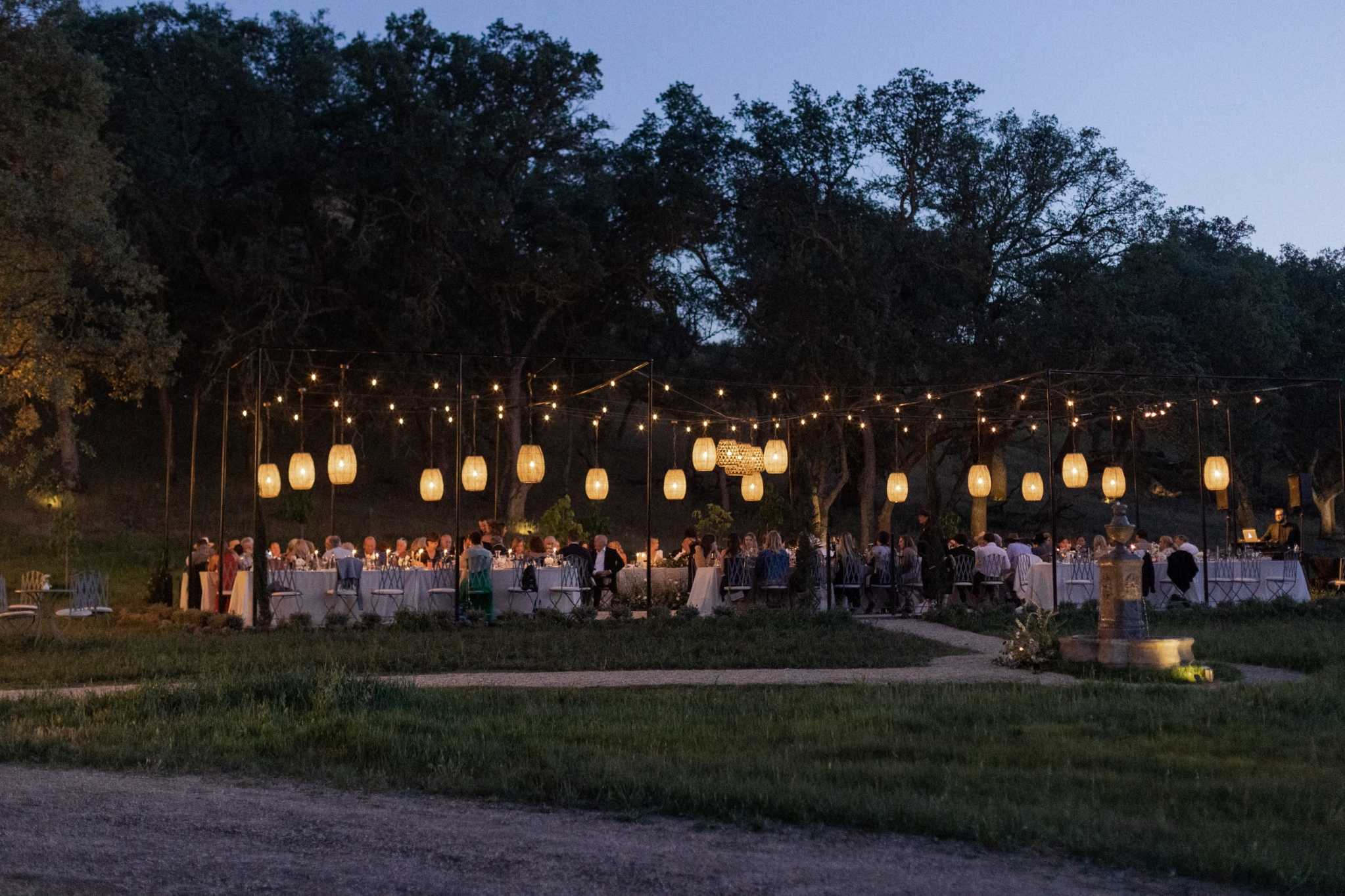 Evening outdoor reception with hanging lanterns for Vermont wedding planners